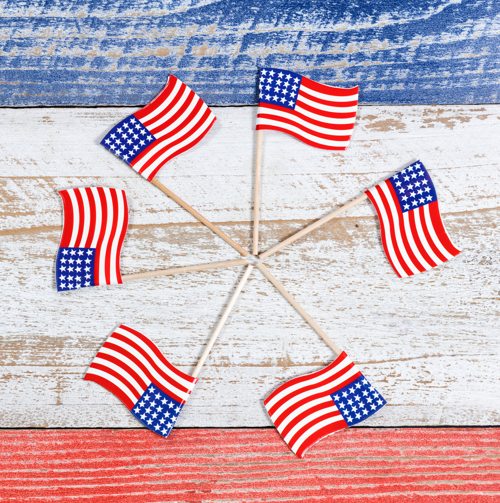 Hot glue small wooden flags in a circle for an easy and patriotic wreath! Here are some darling ideas for 4th of July DIY door wreaths. You will love them!