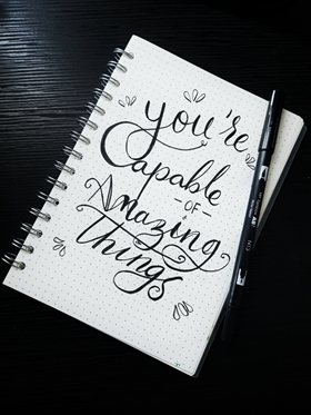 A notebook with a positive mantra written on it - your past doesn't define you.