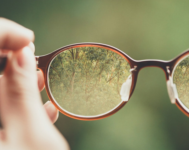 A person holding a pair of glasses